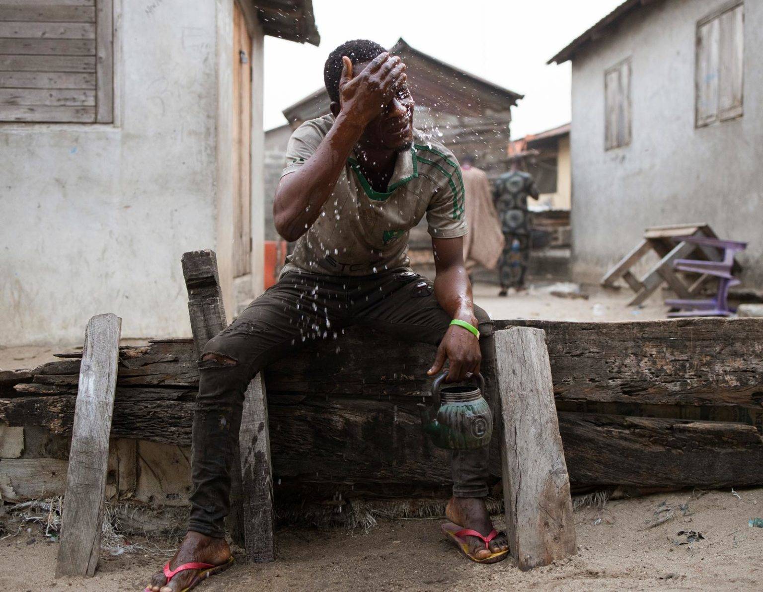 A Sagbo Kodji man takes an early morning wash using well water